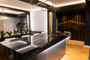 a lobby with a black counter and potted plants at Deluxe Aparthotel MARWELL RESIDENCE in Suceava