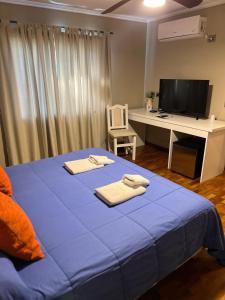 1 dormitorio con 1 cama azul, escritorio y ordenador en Garden House Hotel en Río Cuarto