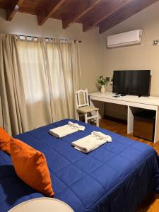 a bedroom with a blue bed with towels on it at Garden House Hotel in Río Cuarto