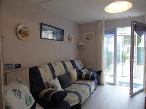 ein Wohnzimmer mit einem Sofa und einer Glasschiebetür in der Unterkunft Maison a 2 pas de la plage in Plage-des-Demoiselles