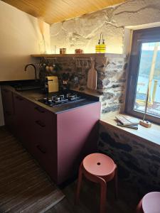 cocina con fogones, taburete y ventana en Viña Candaz, en Taboada