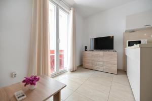 uma sala de estar com uma grande janela e uma televisão em Near old town apartment with free parking and air condition in each room em Zadar