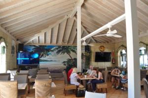 The Palms Golf Del Sur - Casa Andromeda في سان ميغيل ذي أبونا: مجموعة من الناس يجلسون على الطاولات في المطعم