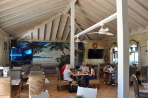 The Palms Golf Del Sur - Casa Andromeda في سان ميغيل ذي أبونا: مجموعة من الناس يجلسون على الطاولات في المطعم