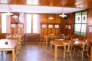 Pilgerhaus Maria-Rickenbach في Dallenwil: غرفة طعام مع طاولات ونوافذ خشبية