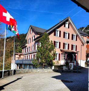 una bandera frente a un edificio rosa en Pilgerhaus Maria-Rickenbach, en Dallenwil