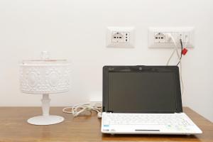 a laptop computer sitting on a desk next to a lamp at Houspitality Caesar Bed & Breakfast in Rome