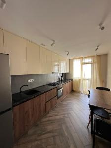 - une cuisine avec des placards en bois et une table dans l'établissement Красиві апартаменти, à Ternopil