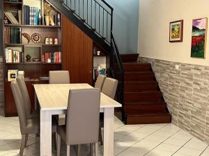 een eetkamer met een tafel en stoelen en een trap bij Relax Sea Capomulini Appartamento su due livelli in Acireale