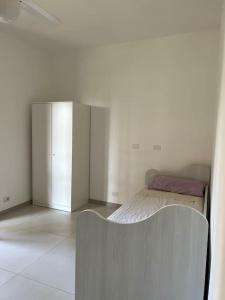 une chambre blanche avec un lit et un placard dans l'établissement Relax Sea Capomulini Appartamento su due livelli, à Acireale