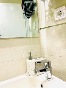 um lavatório de casa de banho com uma torneira e um espelho em MADRID CENTRO em Madri