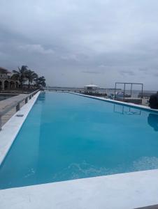 une grande piscine bleue à côté de la plage dans l'établissement Coral View Beach Resort, à Utila
