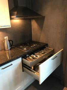 um forno com placa de fogão numa cozinha com armários brancos em Fewo Klimduin Castricum em Castricum