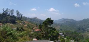 vistas a un valle con árboles y montañas en Hill view villa, en Nuwara Eliya