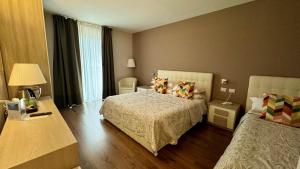 una camera d'albergo con letto e finestra di Hotel Royal a Riva del Garda