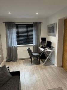 an office with a desk and a computer in a room at Cosy double bedroom with dedicated bathroom in Newcastle upon Tyne - Access to shared kitchen, shared lounge and shared conservatory areas inc Sky TV and Netflix in Newcastle upon Tyne