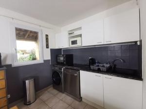 une cuisine avec un évier et une machine à laver dans l'établissement Le Repos du Canal Wifi Parking Piscine Terasse, à Béziers