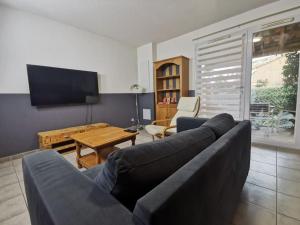 - un salon avec un canapé et une table dans l'établissement Le Nid Canal Piscine Résidence, à Béziers
