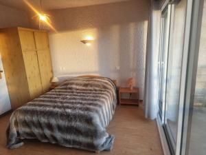 a bedroom with a bed with a blanket on it at Appartement Saint-Michel-de-Chaillol, 2 pièces, 6 personnes - FR-1-393-87 in Saint-Michel-de-Chaillol