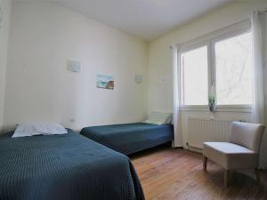 um quarto com uma cama, uma cadeira e uma janela em Villa Lège-Cap-Ferret, 5 pièces, 8 personnes - FR-1-736-34 em Lège-Cap-Ferret