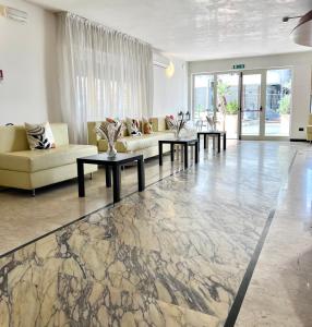 una sala de estar con sofás y mesas en un suelo de mármol. en Hotel B&B Ardea Rimini en Rímini