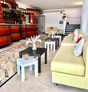 a living room with two couches and tables at Hotel B&B Ardea Rimini in Rimini