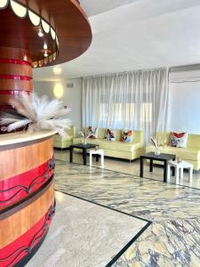 a living room with yellow couches and tables at Hotel B&B Ardea Rimini in Rimini