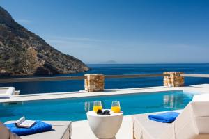 a swimming pool with a view of the ocean at Filadaki Villas in Kamarai