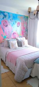 a bedroom with a large bed with a colorful headboard at Apartamento en piso 22 , con increíble vista! Ramón Bautista Mestre 1850, ANTIGUA CERVECERÍA CÓRDOBA in Córdoba
