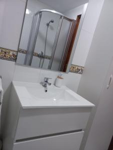 a bathroom with a white sink and a mirror at Apartamento Landra VUT-CO-003165 in Padrón