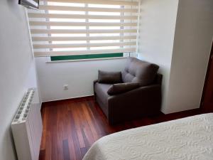 a living room with a chair and a window at Apartamento Landra VUT-CO-003165 in Padrón