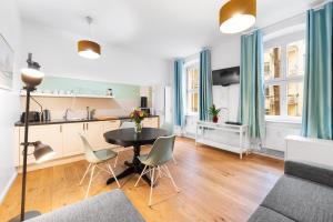 Una cocina y una sala de estar con mesa y sillas. en Lofty Torstr Apartments, 4 unique units from 1-3 bedrooms in Mitte, ideal for families & groups, from 2 up to 8 Guests, en Berlín