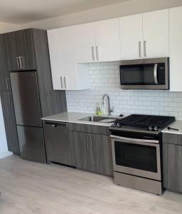 a kitchen with white cabinets and a stove and a sink at Beautiful Downtown apartment, With pool & Balcony in Chicago
