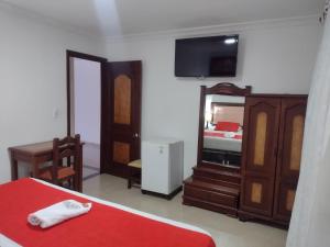 a bedroom with a bed and a mirror at HOTEL NAPOLES in Pitalito