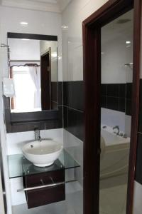 a bathroom with a sink and a mirror and a tub at HOTEL NAPOLES in Pitalito