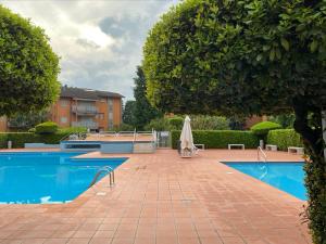 a swimming pool with a umbrella next to a building at Residenza Cappuccini in Peschiera del Garda