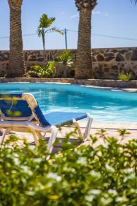 a lounge chair sitting next to a swimming pool at Casa Palmeral in Mácher