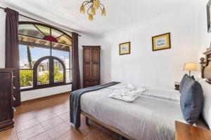 a bedroom with a bed and a large window at Casa Palmeral in Mácher