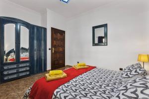 a bedroom with a bed with two yellow towels on it at Casa Palmeral in Mácher