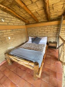 a bed in a room with a wooden ceiling at Mirkeland- Cabaña in Ráquira
