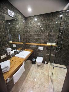 een badkamer met een douche, een wastafel en een toilet bij Гетьман Готель & SPA in Chortkiv