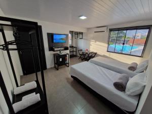 a bedroom with a bed and a flat screen tv at Condomínio Inn The Studio in Foz do Iguaçu
