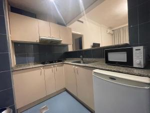 a kitchen with a microwave and a sink at Elegant Suites Beirut in Beirut
