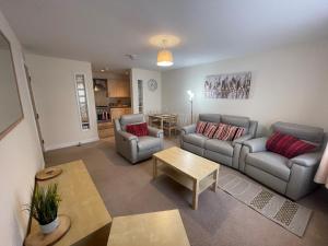 a living room with two couches and a table at Childes Court in Nuneaton