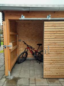 una bicicleta está estacionada en un garaje de madera en Tiny House am Elsbach in der bayerischen Rhön., en Oberelsbach
