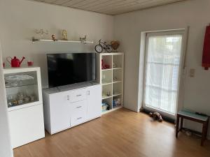 uma sala de estar com um centro de entretenimento branco com uma televisão de ecrã plano em Ferienwohnung DOMiziel für 1 bis 4 Personen im Grünen em Hamm