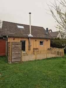 une maison avec une clôture en bois dans une cour dans l'établissement Ferienhäuschen Landleben pur, à Much