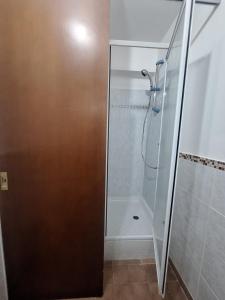 La salle de bains est pourvue d'une douche avec une porte en verre. dans l'établissement Casa Vacanze MAMI home 2/5 pers., à San Cesareo