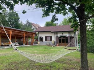 uma rede em frente a uma casa em Moretti Mountain House - Relax in Nature em Gorreta