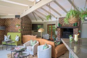 a living room filled with furniture and a fireplace at The Fernery Lodge & Spa in Stormsrivier +72 photos